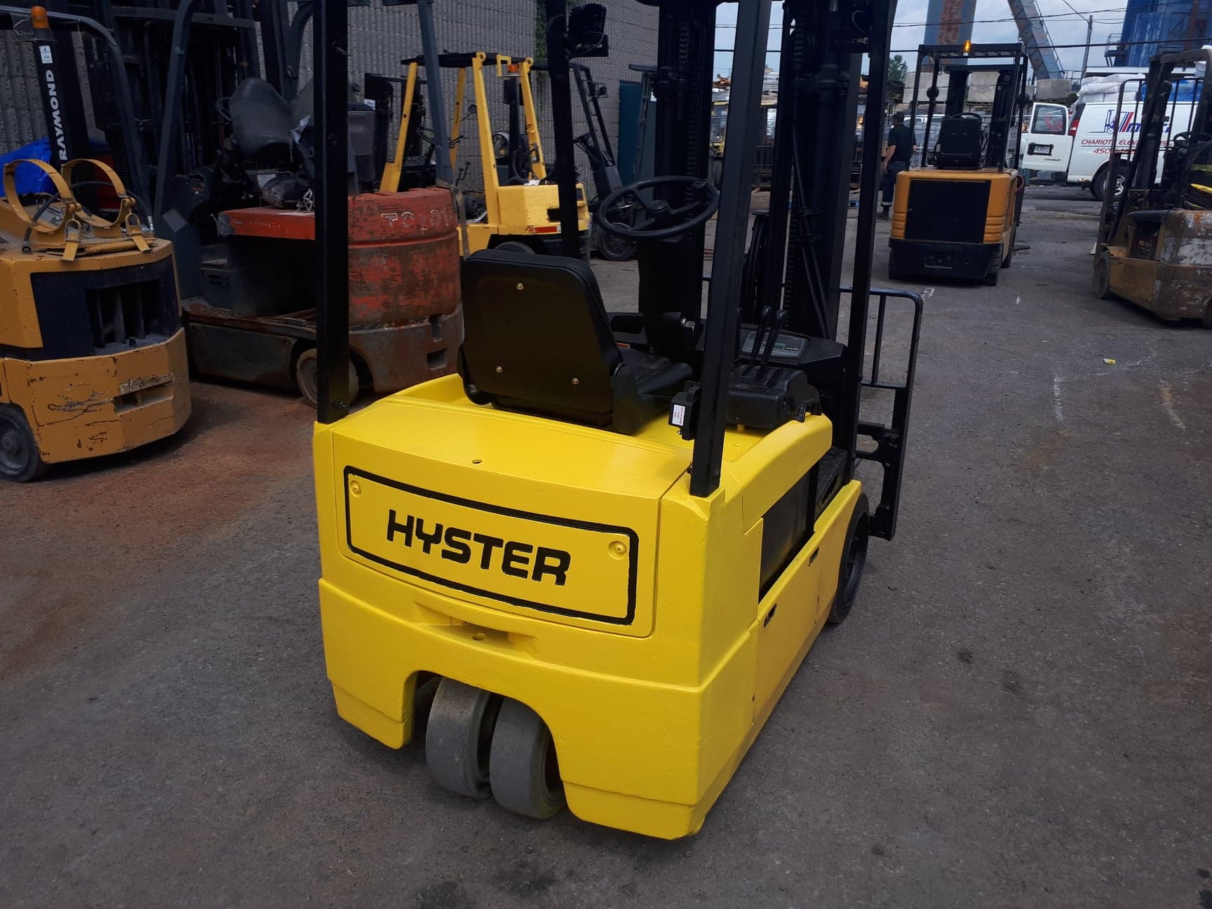 A yellow hyster forklift is parked in a parking lot
