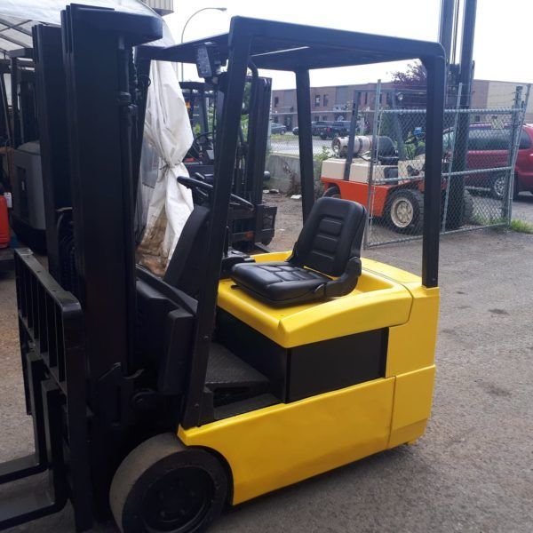 Un chariot élévateur jaune est garé sur un parking