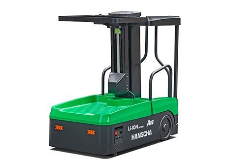 Véhicule à guidage automatique (AGV) vert et noir avec mécanisme de levage, utilisé pour la manutention de matériaux dans un entrepôt.
