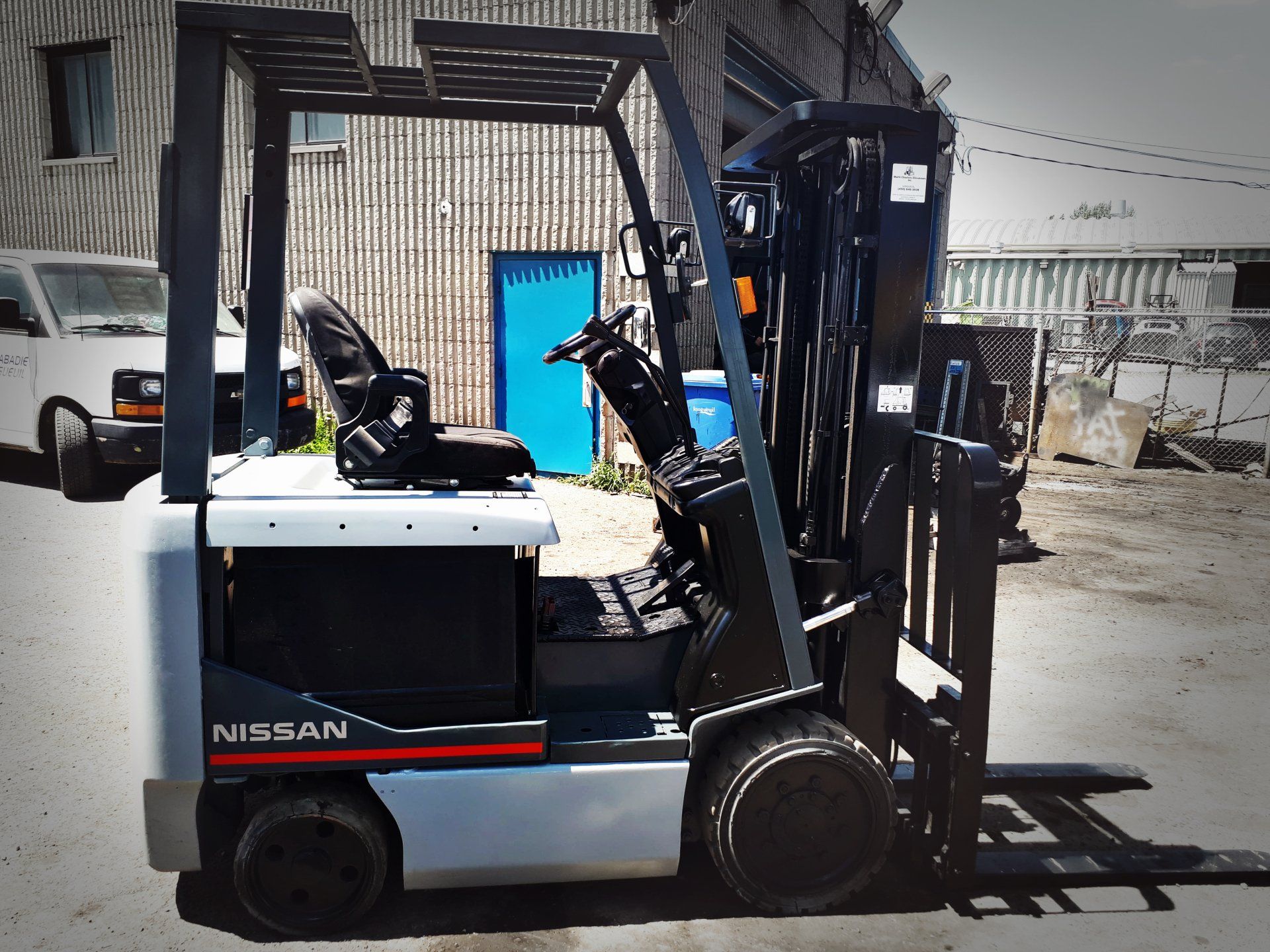 Un chariot élévateur Nissan est garé devant un bâtiment