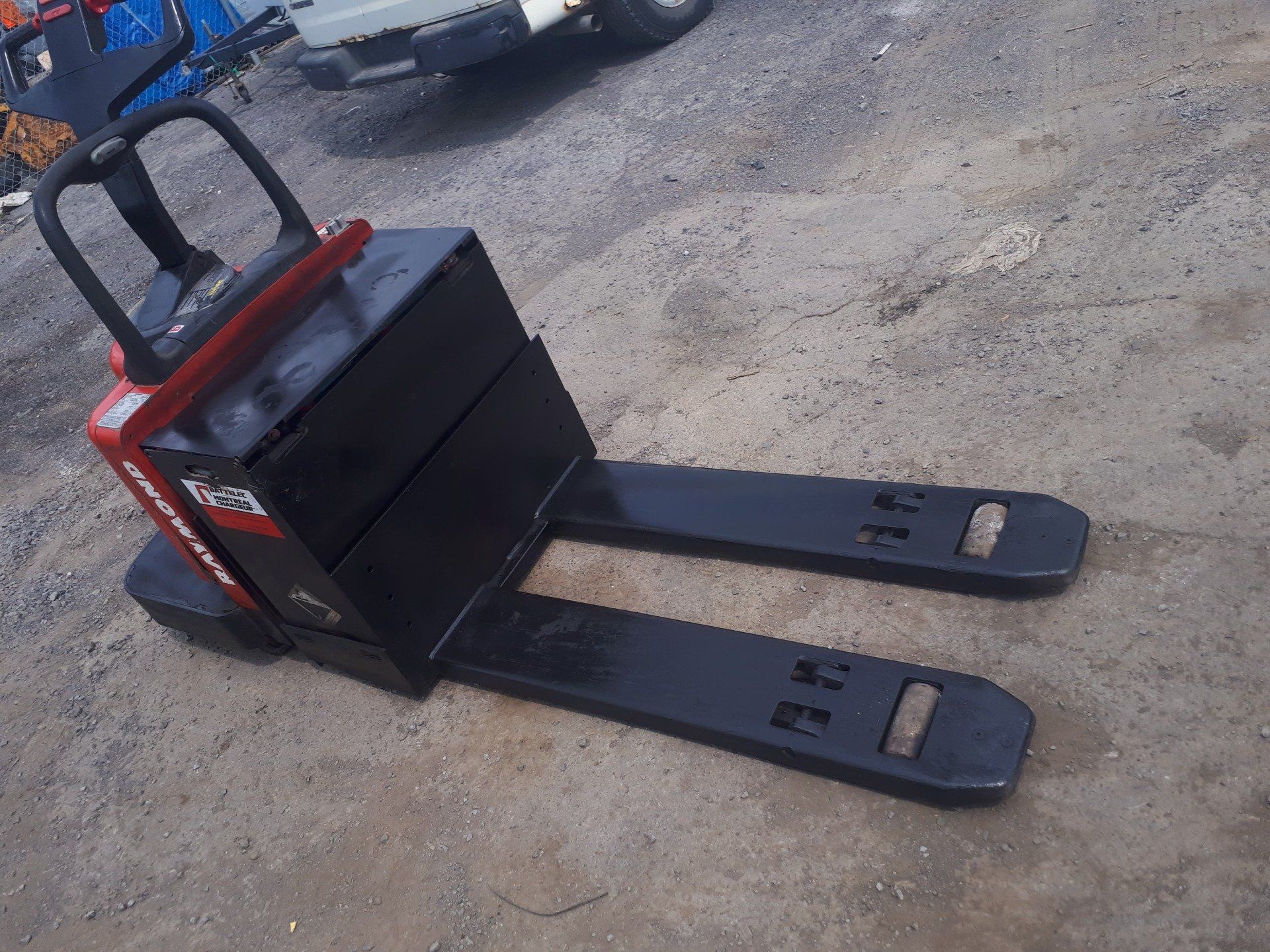 A red and black forklift is sitting on the ground