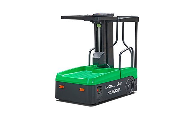 Véhicule à guidage automatique (AGV) vert et noir avec mécanisme de levage, utilisé pour la manutention de matériaux dans un entrepôt.