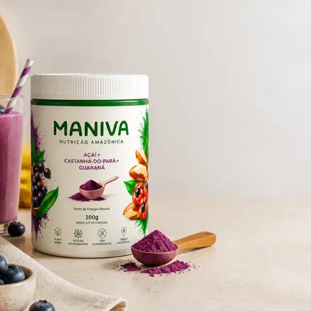 Pote de pó de maca Maniva com colher medidora roxa sobre uma mesa clara.