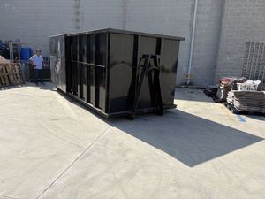 A white box truck parked on a paved lot under a clear blue sky.