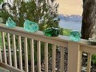 A wooden railing with green glass sculptures on it.