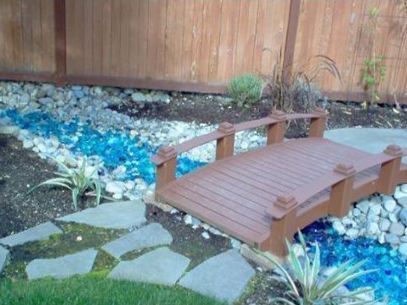 A wooden bridge over a stream in a garden
