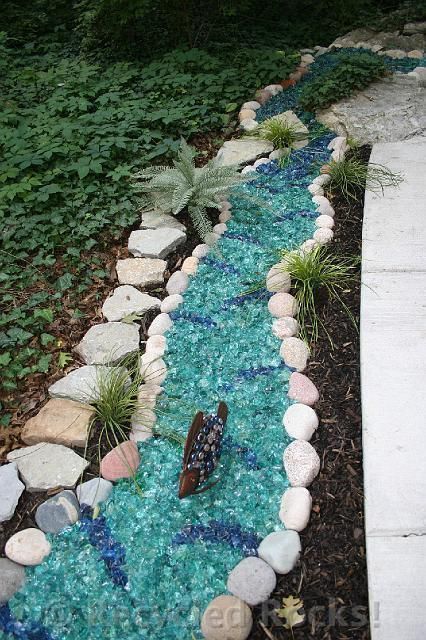 A butterfly is sitting on a rock in the middle of a garden.