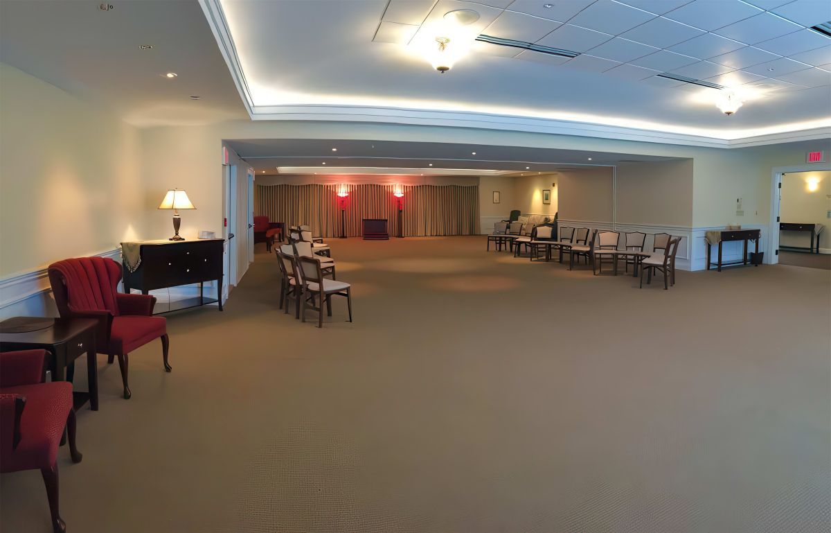 Interior of a room with chairs arranged for a ceremony; neutral color scheme, warm lighting.