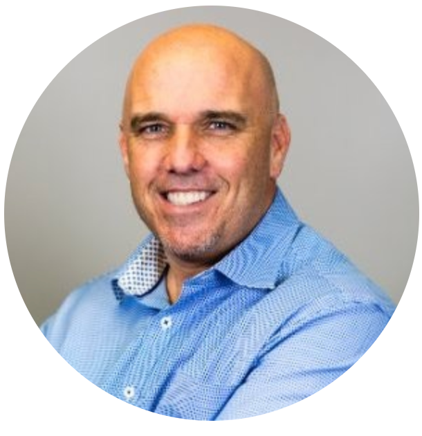 A bald man in a blue shirt is smiling in a circle.