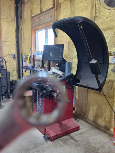 Hands in work gloves tighten a bolt on a car engine with wrenches.