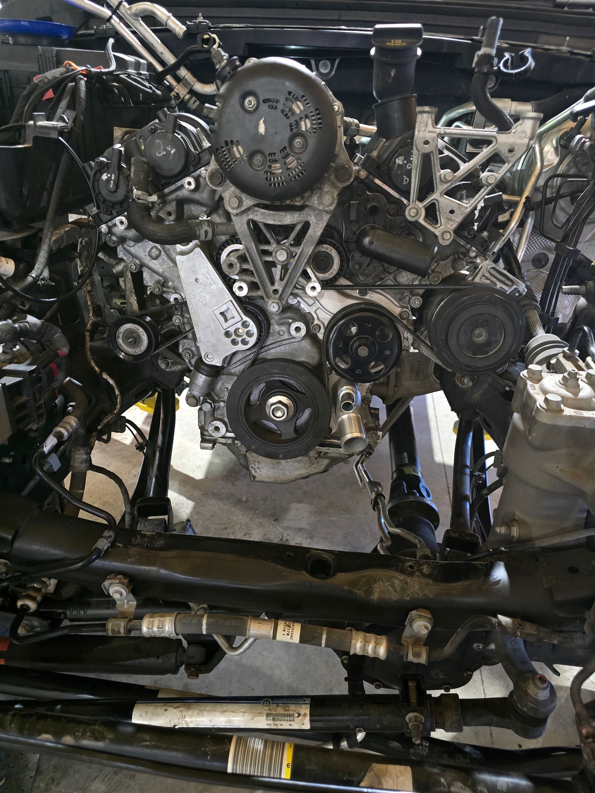Car parts: spark plugs, bearings, gear, and other mechanical components on a dark surface.