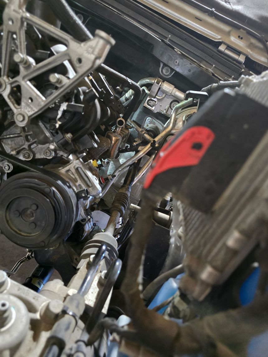 Red classic car engine with three carburetors, painted teal, open hood.