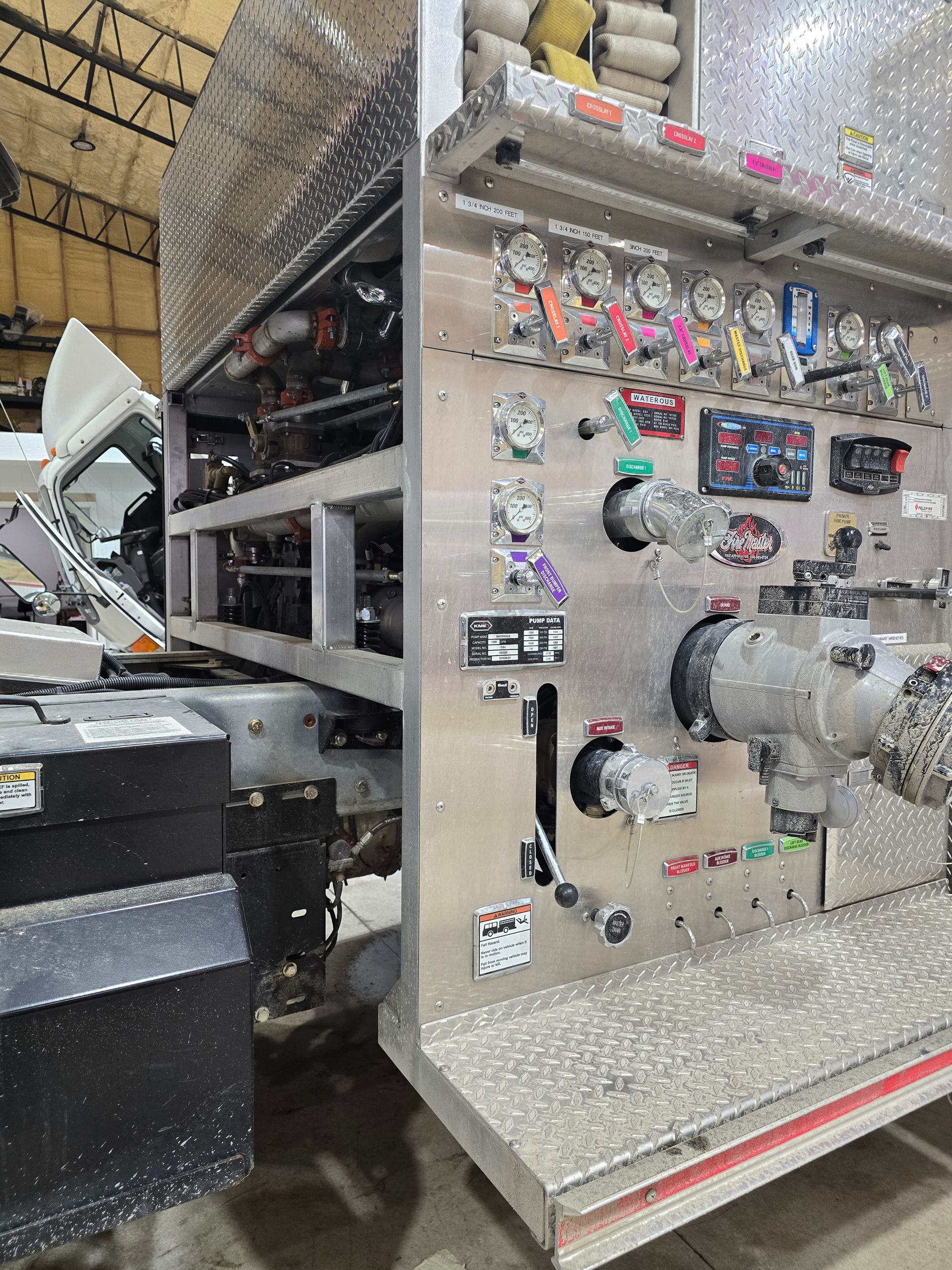 Metal control panel with switches and gauges on an industrial machine in a factory.