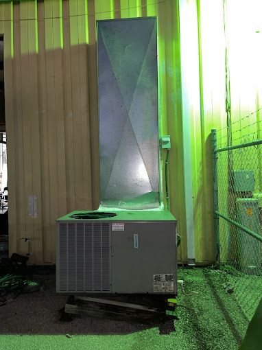 a large air conditioner is sitting outside of a building