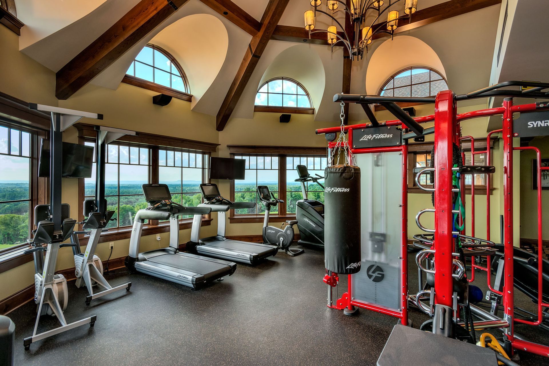gym with a lot of equipment and a lot of windows.