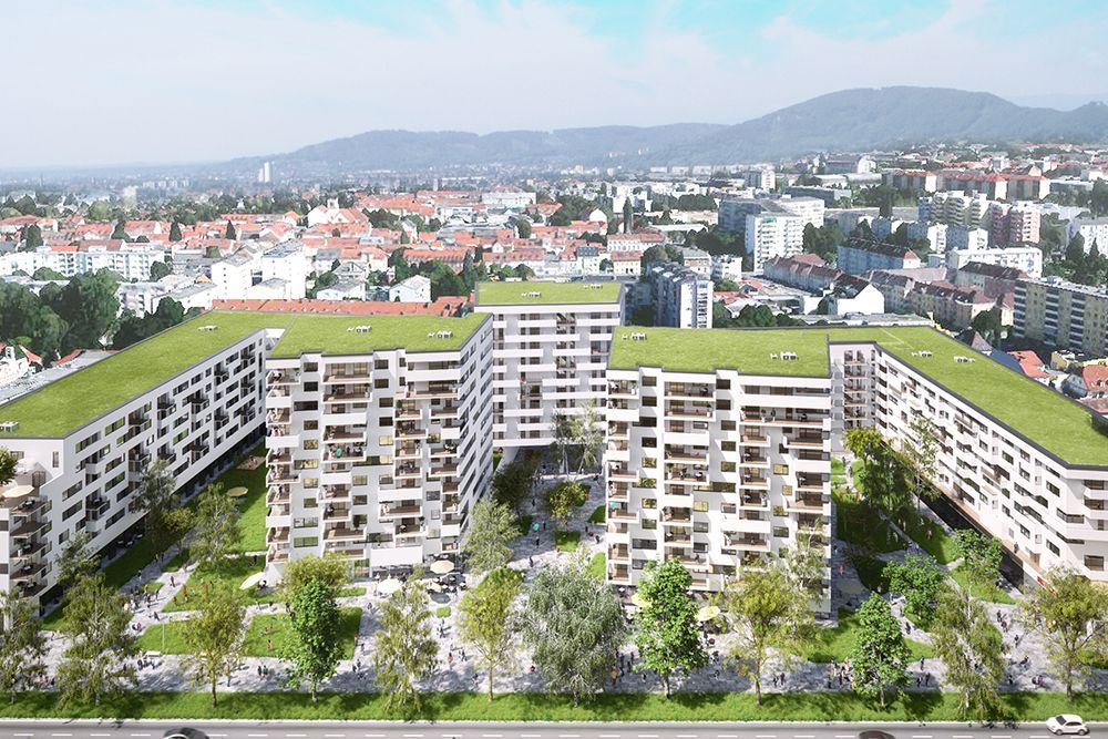 Luftaufnahme eines modernen Apartmentkomplexes mit begrünten Innenhöfen und der Skyline der Stadt im Hintergrund