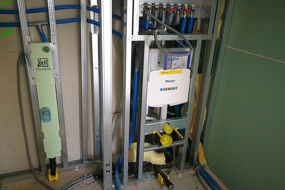 Elektrische Versorgungseinrichtungen und Rohrleitungen in einem wandmontierten Verteilerschrank