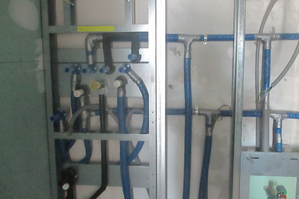 Blaue elektrische Kabel und Leitungen sind an einer Wand in einem unfertigen Raum montiert.
