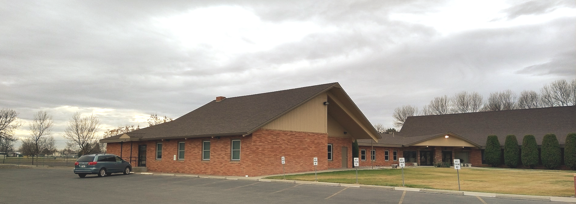 A brick building with a car parked in front of it