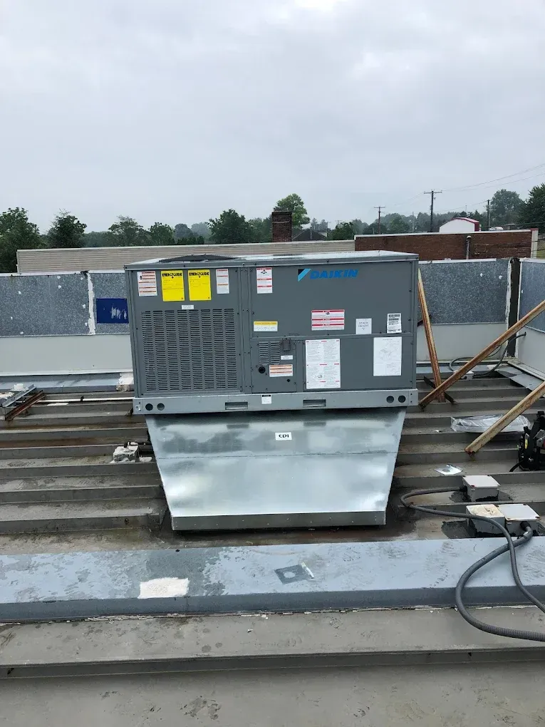 A large air conditioner is sitting on top of a roof.
