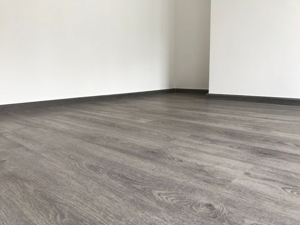 An Empty Room with A Wooden Floor and White Walls — Geoff Thompson's Independent Flooring Centre In Port Macquarie, NSW An Empty Room with A Wooden Floor and White Walls — Geoff Thompson's Independent Flooring Centre In Port Macquarie, NSW