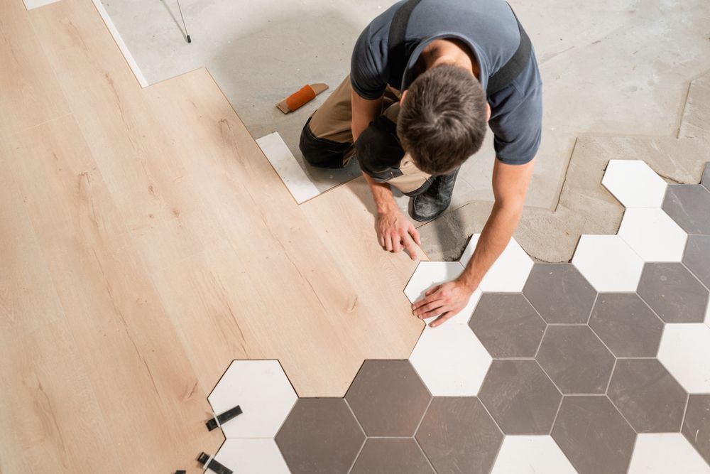 A Man Is Installing a Wooden Floor with Hexagonal Tiles — Geoff Thompson's Independent Flooring Centre In Port Macquarie, NSW