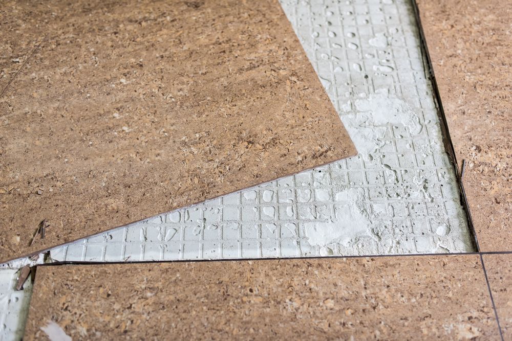 A Close up Of a Piece of Cork Tile on A Tiled Floor — Geoff Thompson's Independent Flooring Centre In Port Macquarie, NSW