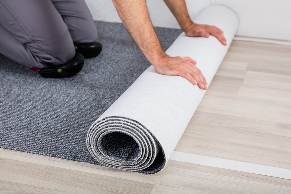 Close-Up Of Worker's Hands Unrolling Carpet — Geoff Thompson's Independent Flooring Centre In Port Macquarie, NSW
