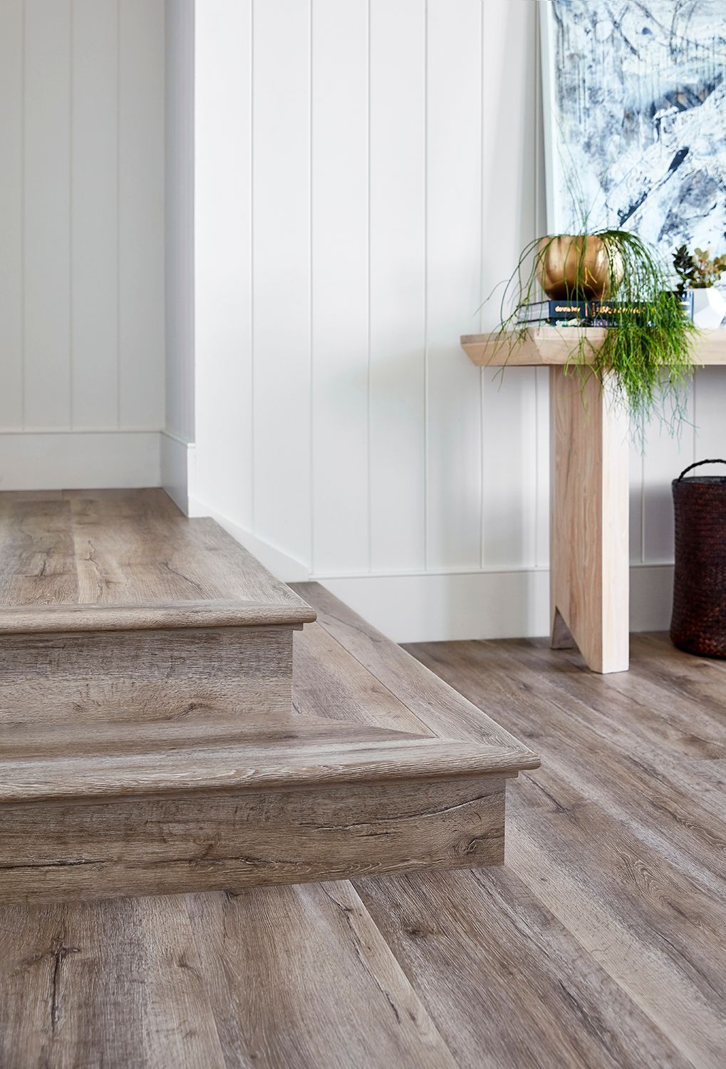 A Hallway with Wooden Stairs and A Wooden Table — Geoff Thompson's Independent Flooring Centre In Port Macquarie, NSW