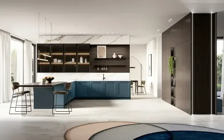 Cucina moderna con mobili blu, isola nera con sgabelli e mobile a muro marrone scuro. Sono visibili il paraschizzi in marmo e un tappeto colorato.
