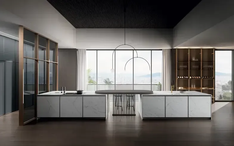 Cucina moderna con due isole effetto marmo, ampie finestre con vista sul paesaggio, soffitto scuro e lampadario decorativo.
