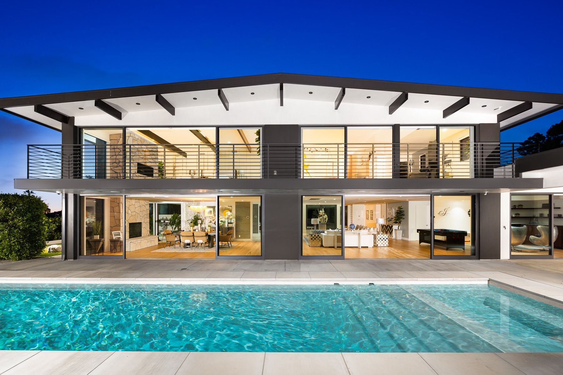 Photo showing an upscale home with easy pool access, second floor balcony and more