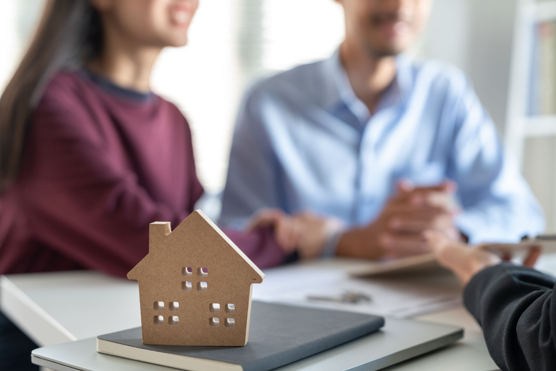 Older couple consults with a woman in their living room. All smiling and looking at documents.