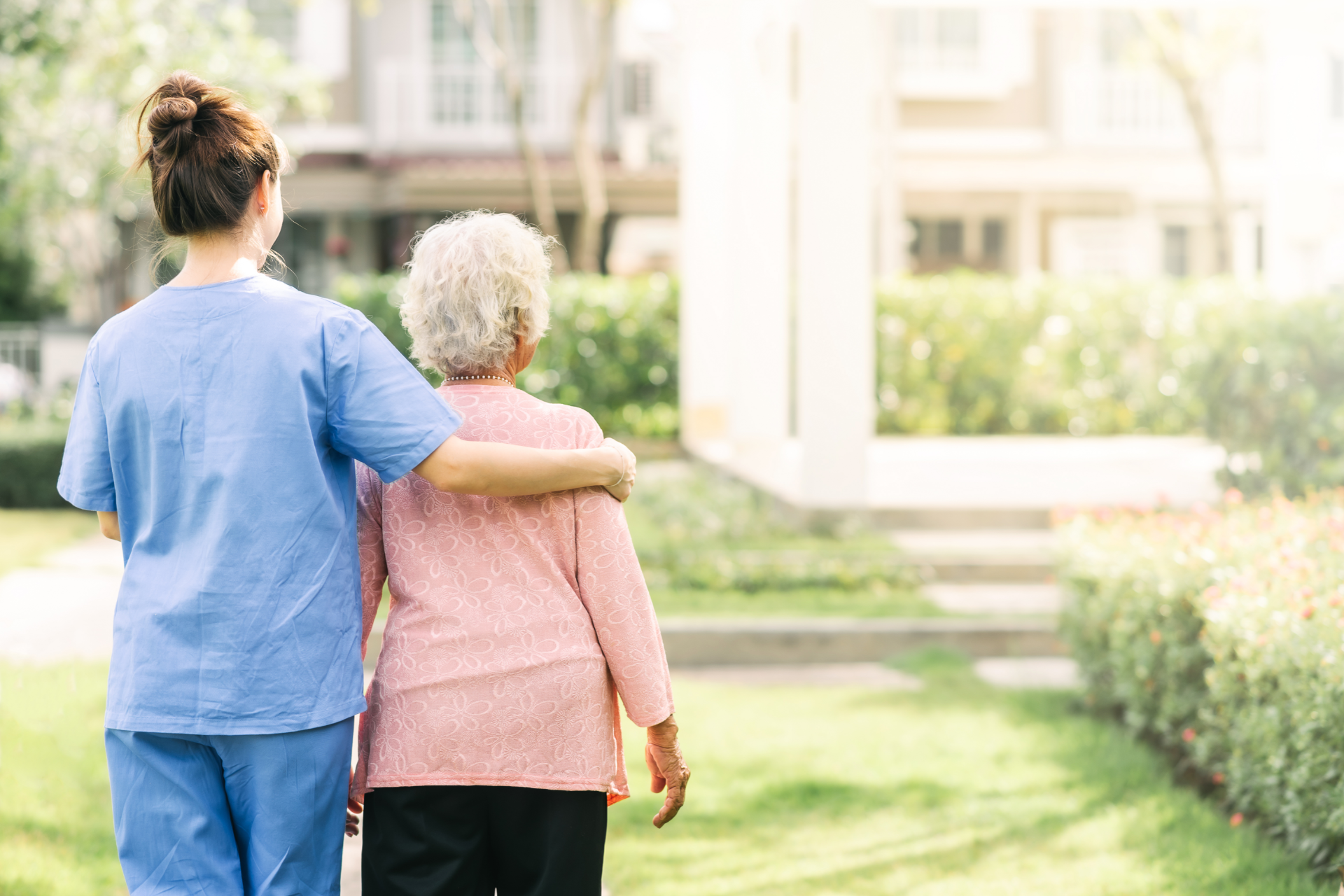 Older couple smiles while consulting with a person about documents in a home setting.