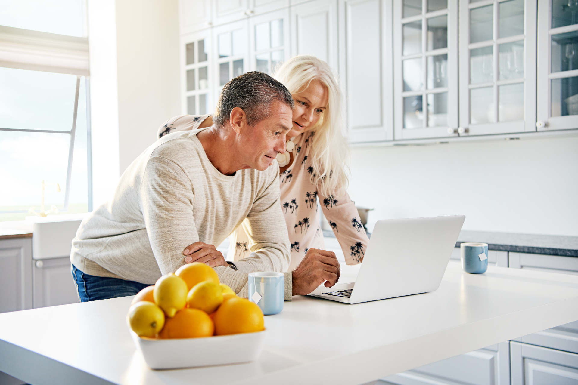 Senior couple talking with a woman, possibly a financial advisor, in a home setting.