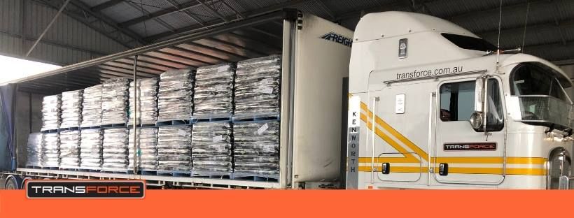 White Semi Truck is Parked in a Warehouse Filled With Pallets — Transforce in Parkes, NSW