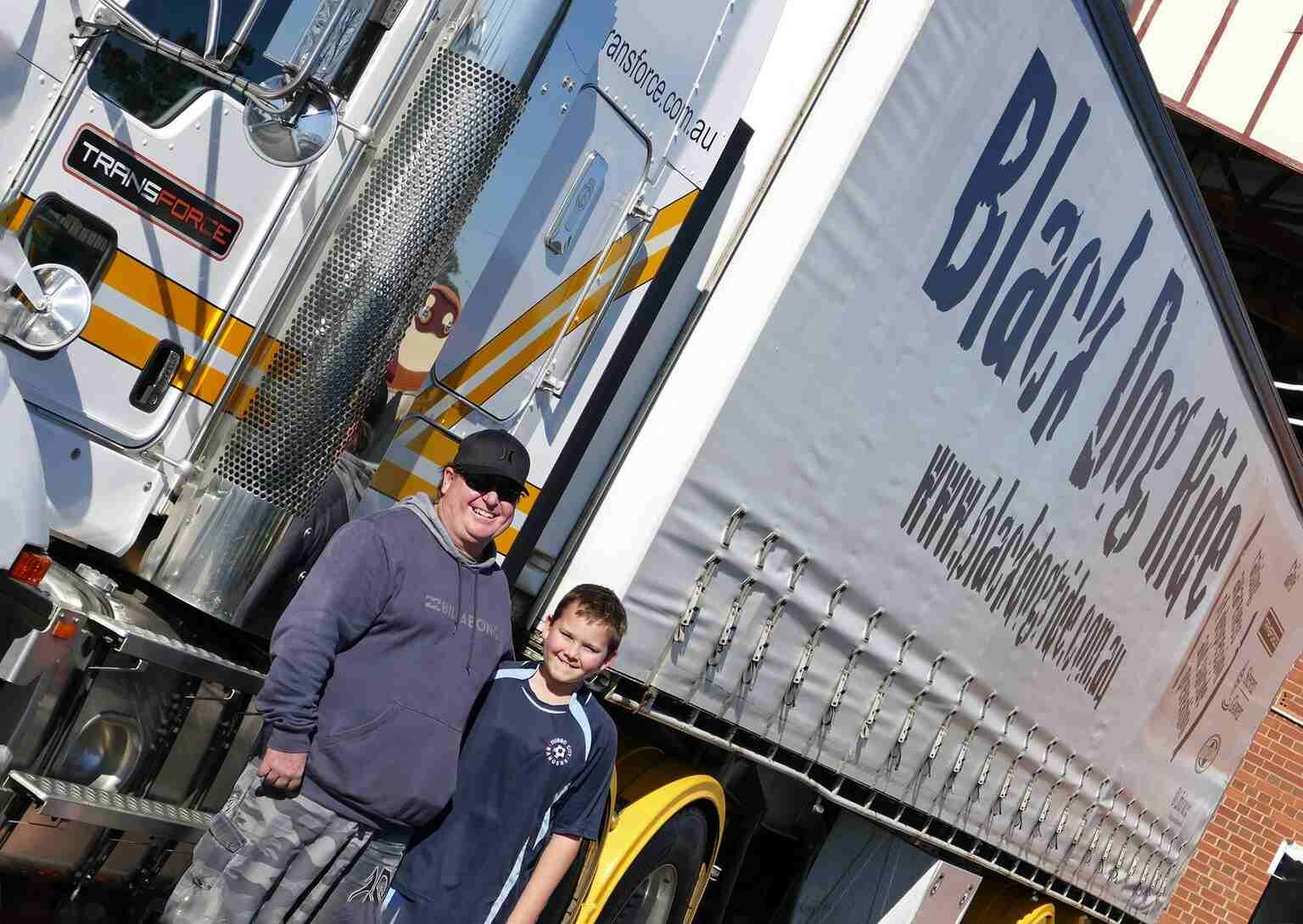 Man and a Boy Standing in Front of a Truck That Says Black Dog Rides — Transforce in Narromine, NSW