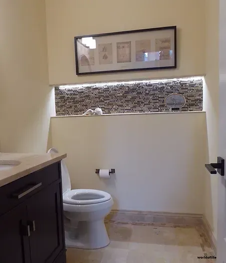 A bathroom with a toilet a sink and a picture on the wall