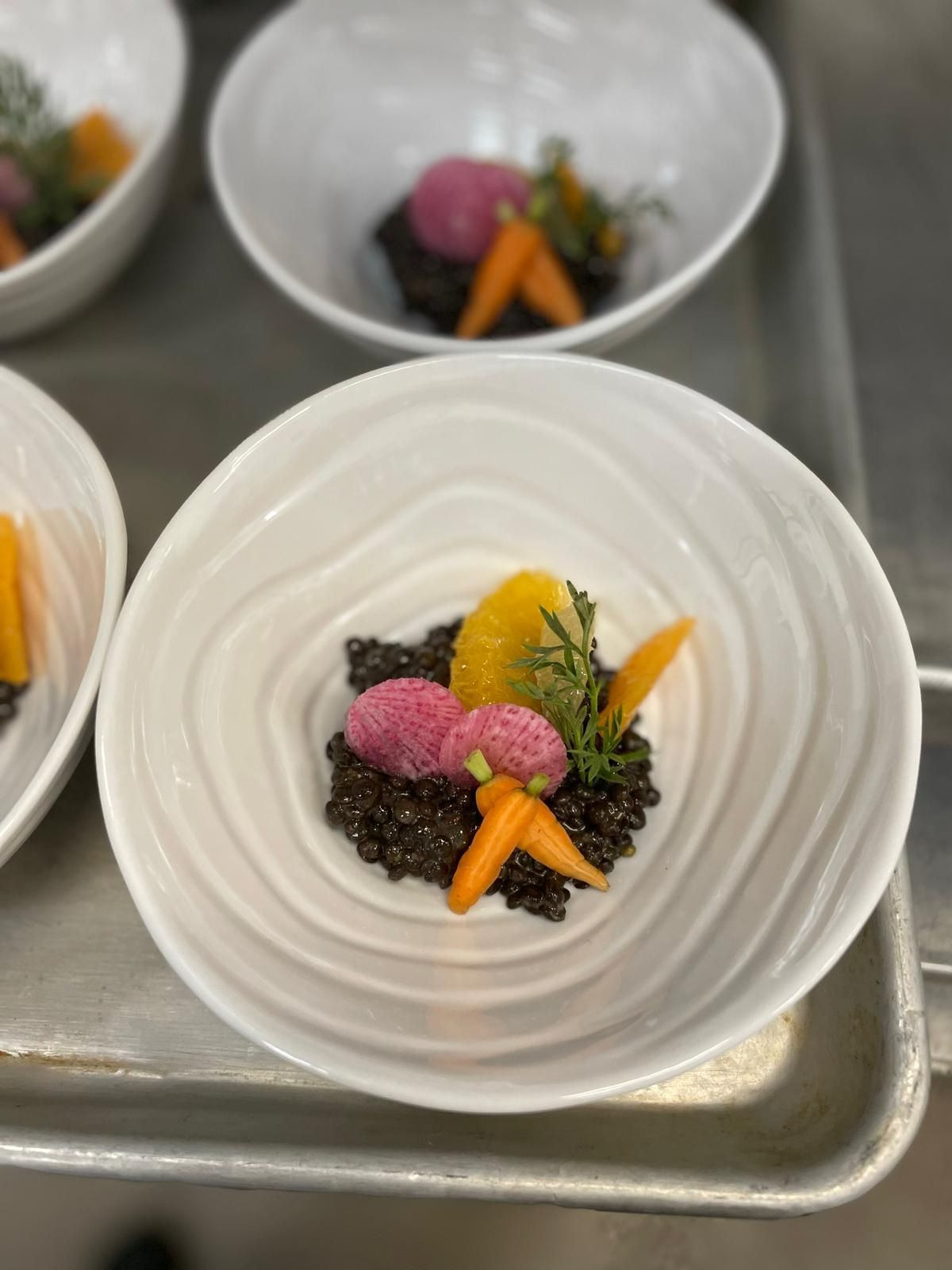 A plate of food with carrots and lentils on a tray