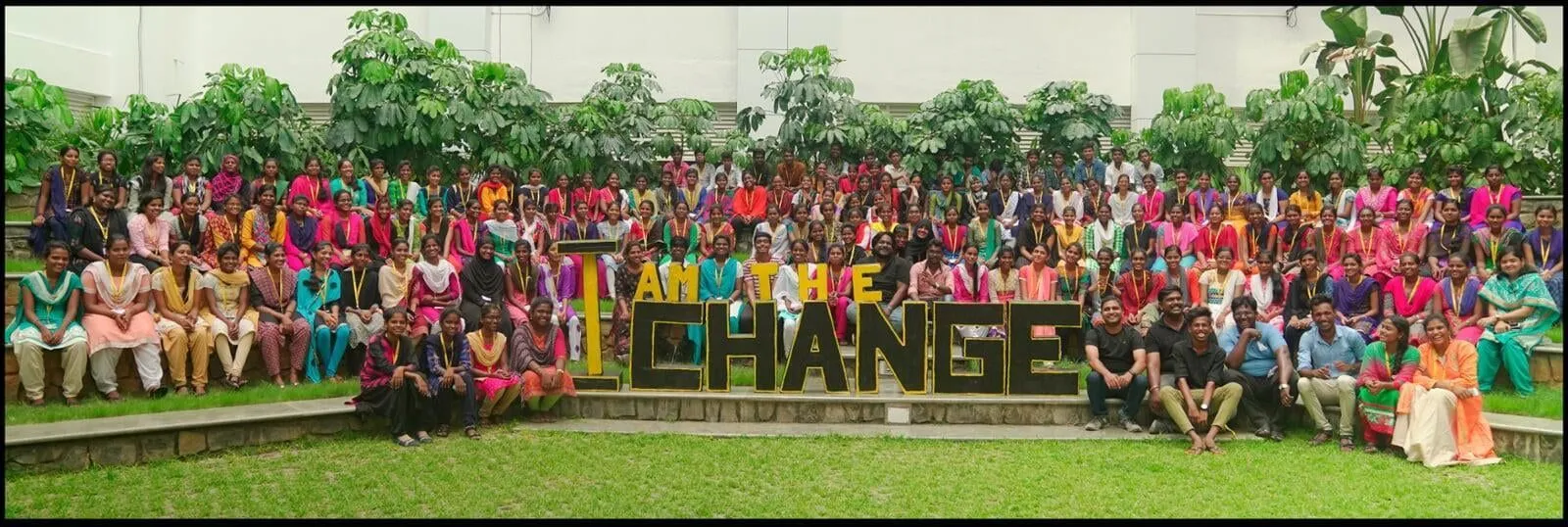 A large group of people standing in front of a sign that says change