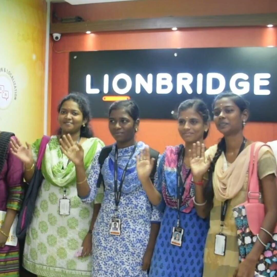 A group of women standing in front of a sign that says lionbridge