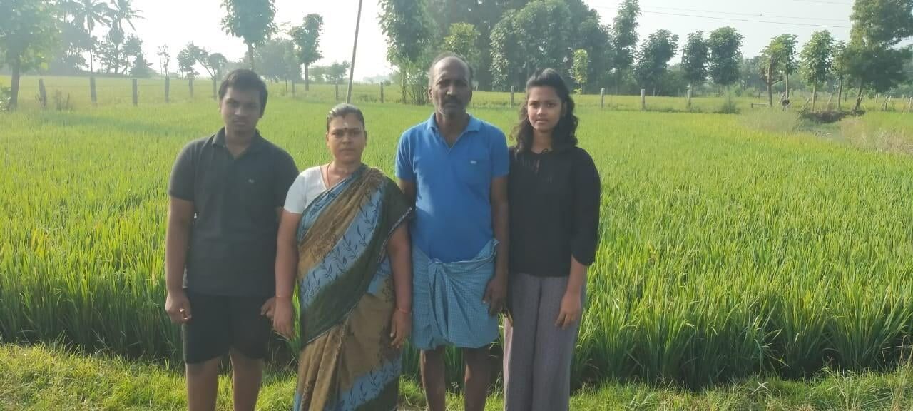 A group of people are standing in a field of grass.