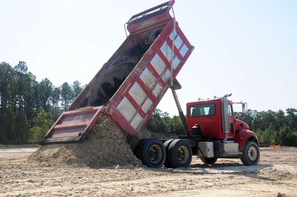 Dump truck delivering gravel and aggregate material to a construction site