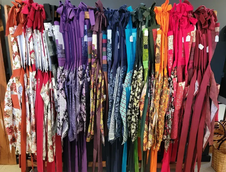 A bunch of colorful clothes are hanging on a rack A bunch of colorful clothes are hanging on a rack