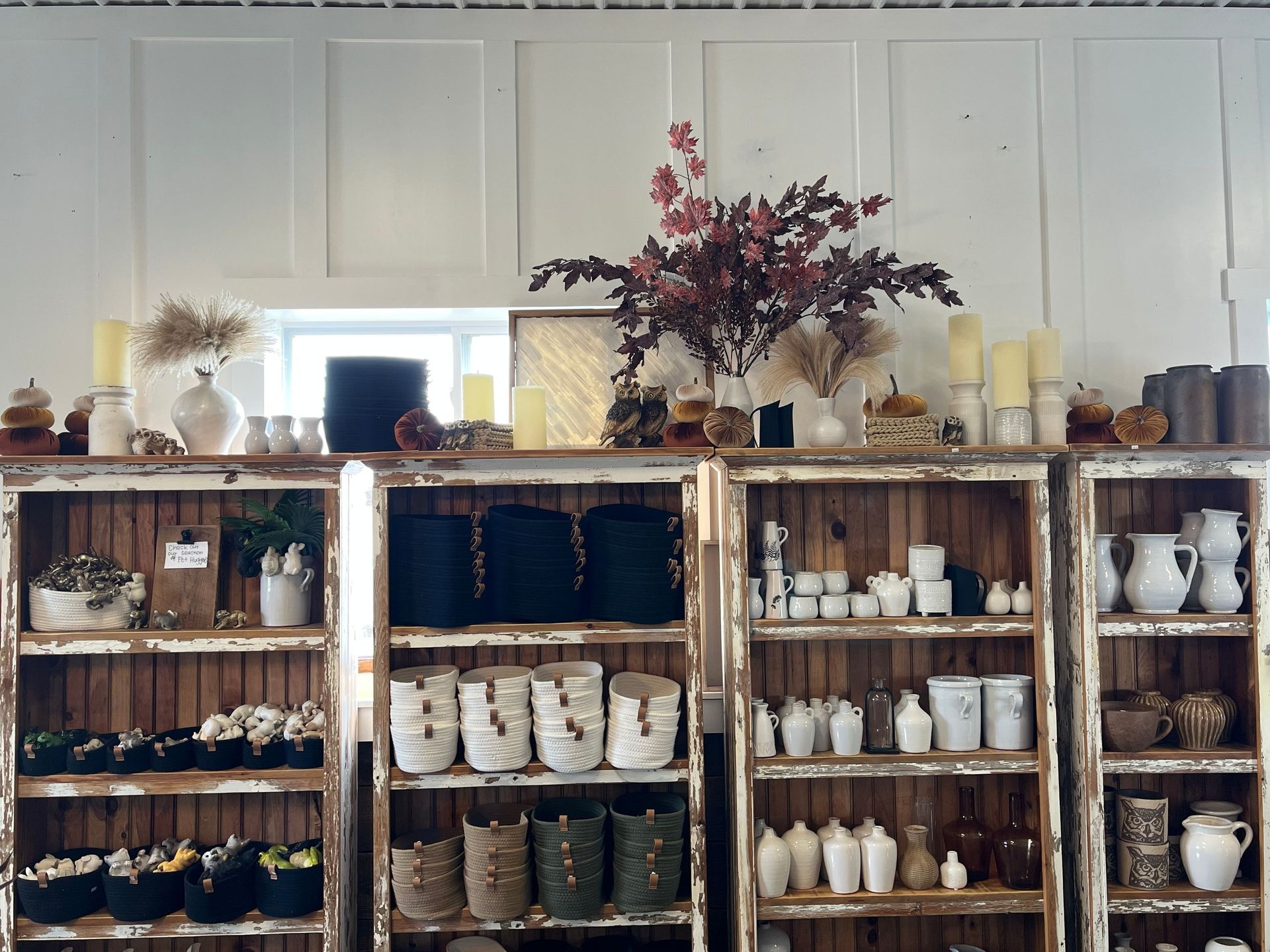 A shelf full of wicker baskets and a sign that says ' handmade ' on it