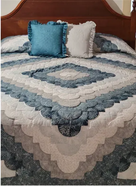 A bed with a quilt and pillows on it A bed with a quilt and pillows on it