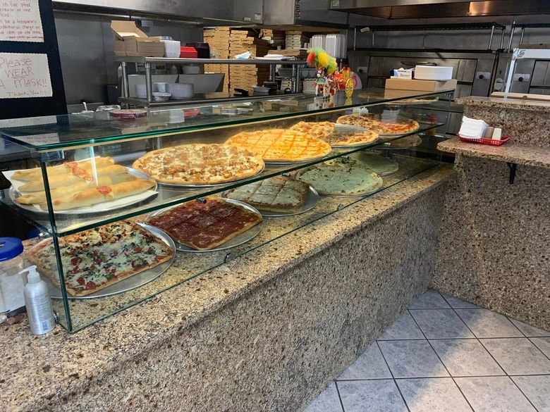 Bakery display case with assorted pastries and desserts on a granite counter