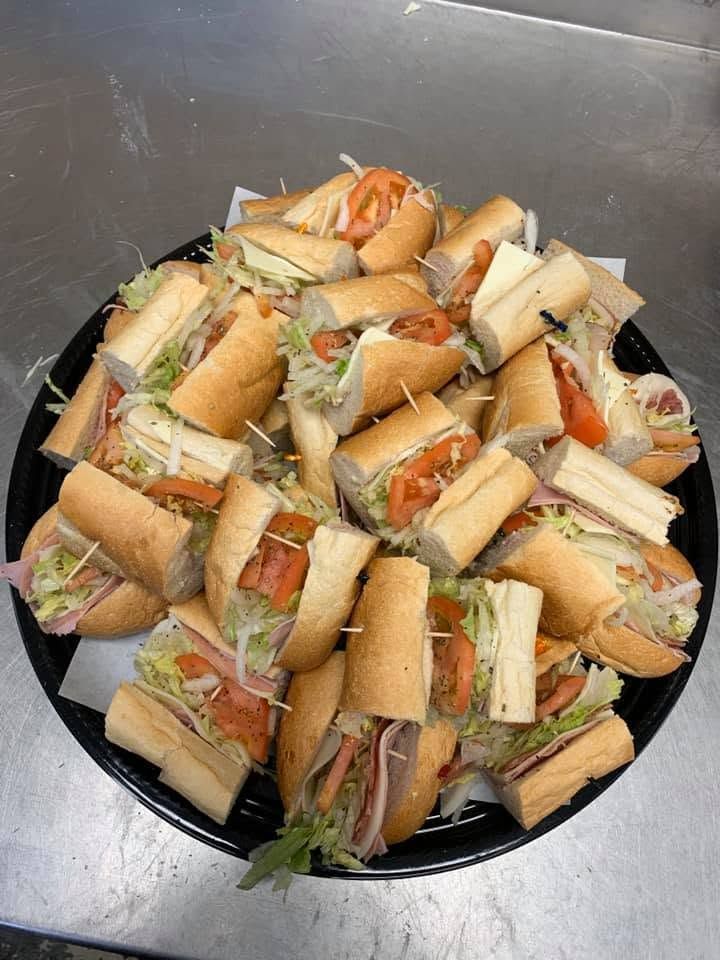 A plate piled with assorted sandwich pieces on a dark surface.