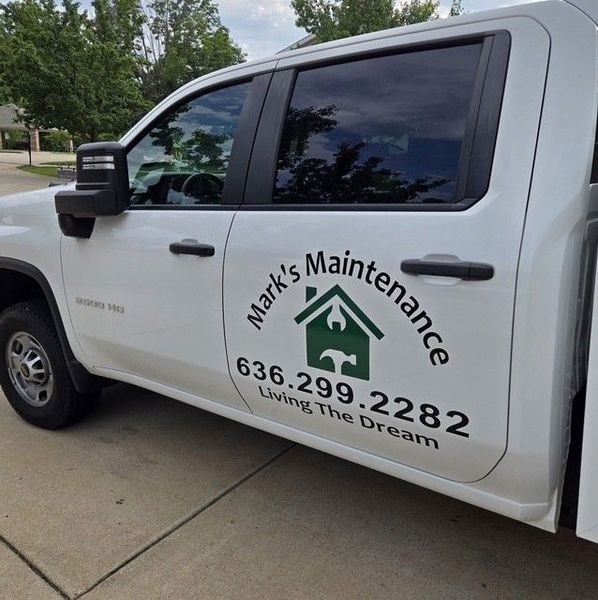 White truck with “Mark’s Maintenance” logo, phone number, and “Living the Dream” on the door.