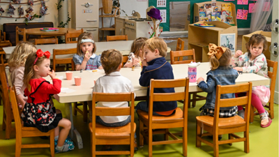 preschool aged boys and girls sitting around a table eating snacks